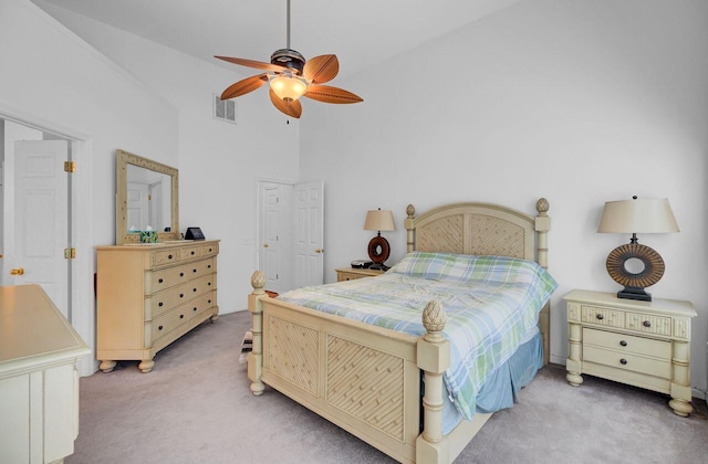 bedroom with high vaulted ceiling, visible vents, light colored carpet, and a ceiling fan