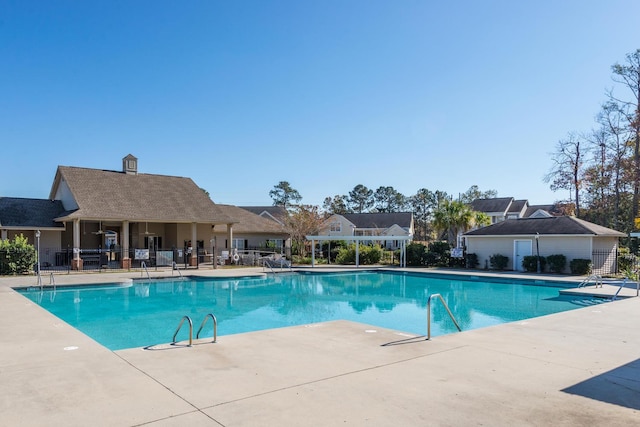 pool with a patio and fence