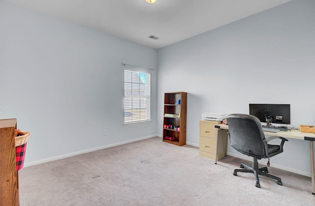 office featuring visible vents, light carpet, and baseboards