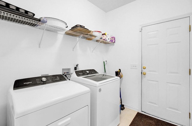 washroom featuring light tile patterned flooring, laundry area, and washing machine and clothes dryer