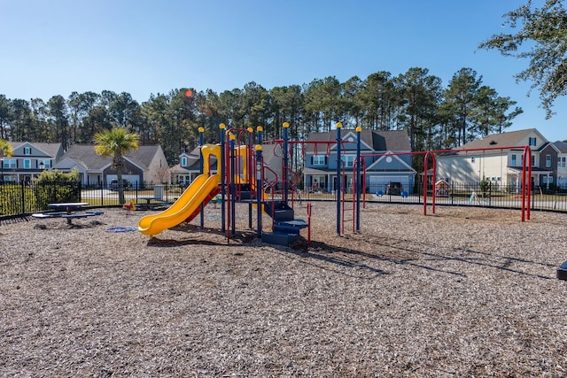 community play area featuring fence and a residential view