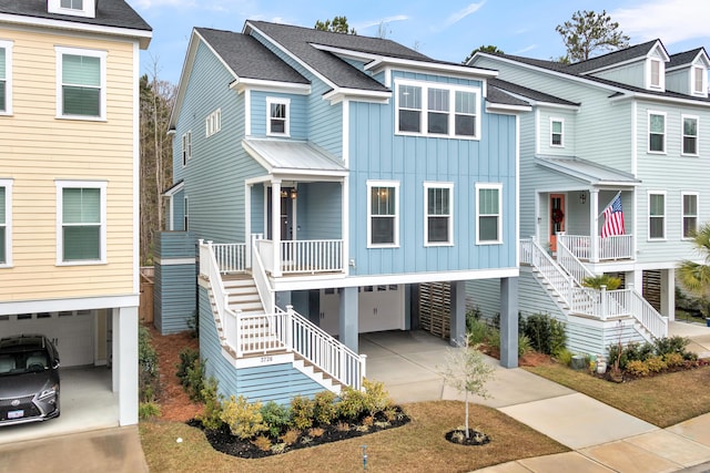 coastal inspired home with a carport, a porch, an attached garage, and board and batten siding