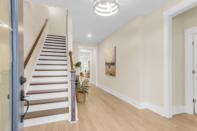 interior space featuring light wood finished floors, recessed lighting, stairs, and baseboards