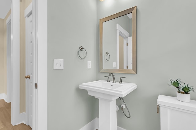 half bath featuring toilet and wood finished floors