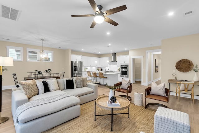 living room with visible vents, light wood-style flooring, a ceiling fan, recessed lighting, and baseboards