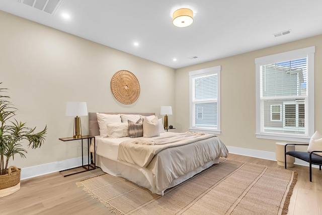 bedroom featuring light wood-style flooring, baseboards, and visible vents