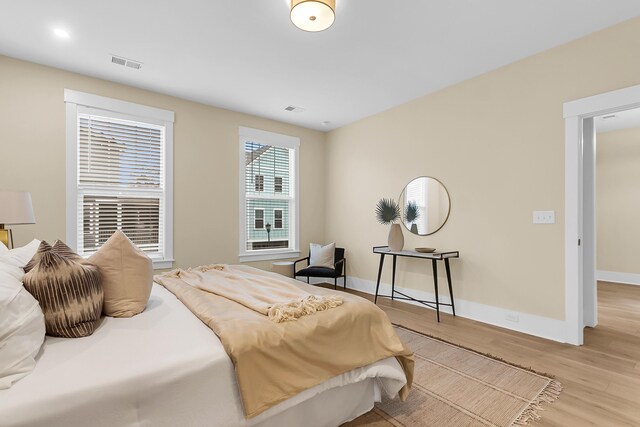 bedroom featuring visible vents, light wood-type flooring, and baseboards