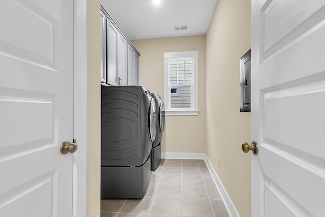 washroom with visible vents, washer and clothes dryer, cabinet space, light tile patterned floors, and baseboards