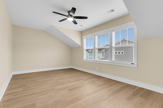 bonus room featuring a ceiling fan, visible vents, baseboards, vaulted ceiling, and light wood-type flooring