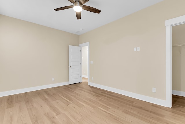 unfurnished room with baseboards, a ceiling fan, and light wood finished floors