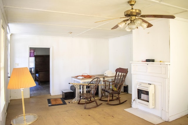 dining area with ceiling fan, heating unit, and light wood-style flooring