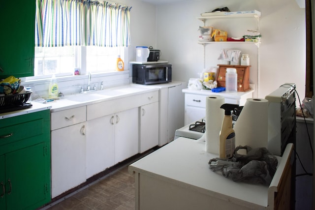 kitchen featuring open shelves, a sink, black microwave, light countertops, and white cabinets
