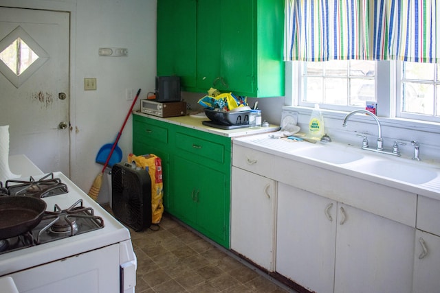 kitchen featuring white gas stove, light countertops, white cabinets, and a sink