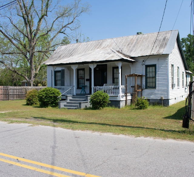 bungalow-style house with crawl space, metal roof, fence, a porch, and a front yard
