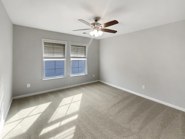 spare room with baseboards, carpet, and a ceiling fan