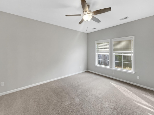 unfurnished room featuring carpet, a ceiling fan, visible vents, and baseboards