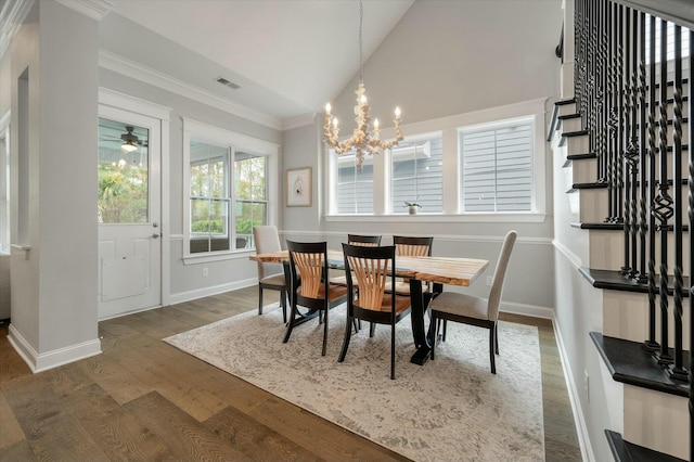 dining space featuring dark wood-type flooring, lofted ceiling, crown molding, and a chandelier