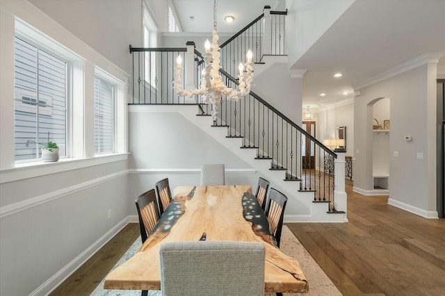 dining area with dark hardwood / wood-style flooring, ornamental molding, and a chandelier