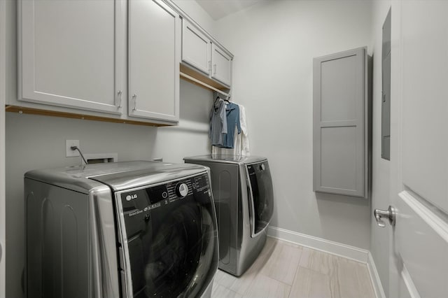 washroom featuring cabinets and washer and clothes dryer