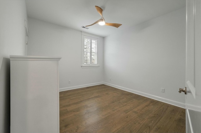 spare room with dark hardwood / wood-style floors and ceiling fan