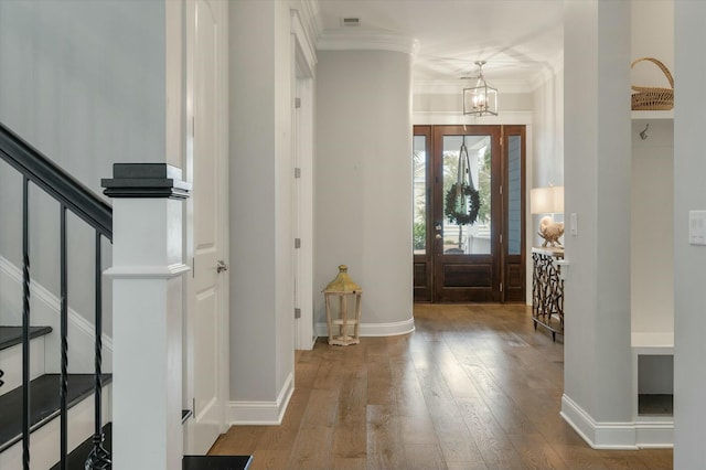 entryway featuring an inviting chandelier, crown molding, and hardwood / wood-style floors