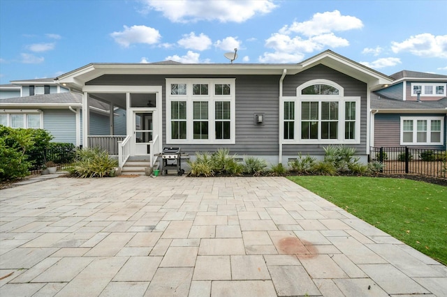 rear view of house featuring a yard and a sunroom