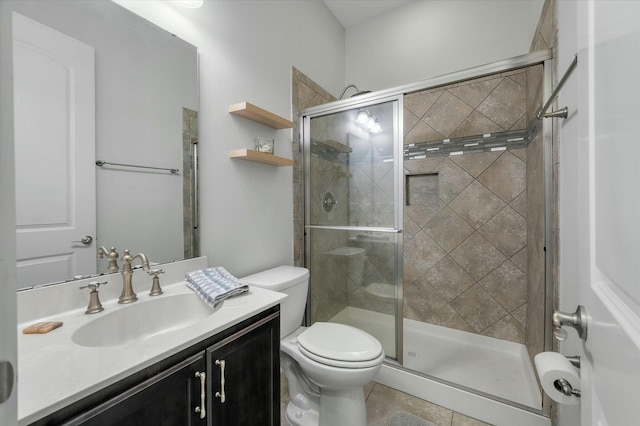 bathroom with vanity, a shower with shower door, tile patterned floors, and toilet