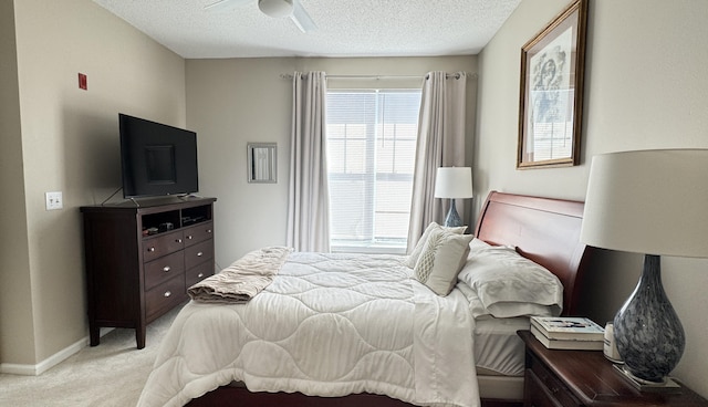 bedroom featuring a ceiling fan, light carpet, a textured ceiling, and baseboards