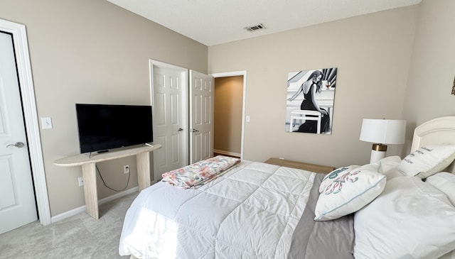 bedroom featuring baseboards, visible vents, and light colored carpet