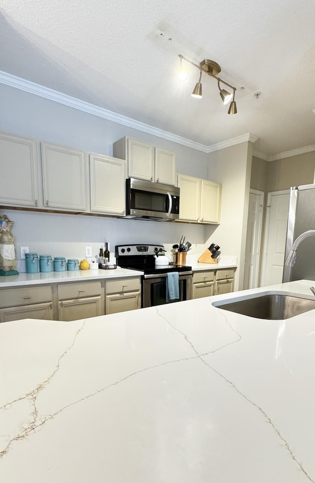 kitchen with appliances with stainless steel finishes, light stone countertops, crown molding, a textured ceiling, and a sink