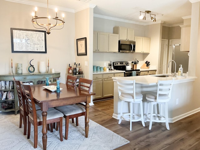 dining area featuring ornamental molding, a chandelier, baseboards, and wood finished floors