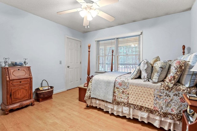 bedroom featuring ceiling fan, light hardwood / wood-style floors, and a textured ceiling