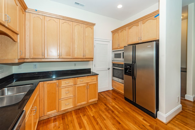 kitchen featuring stainless steel appliances, dark hardwood / wood-style floors, light brown cabinets, and sink