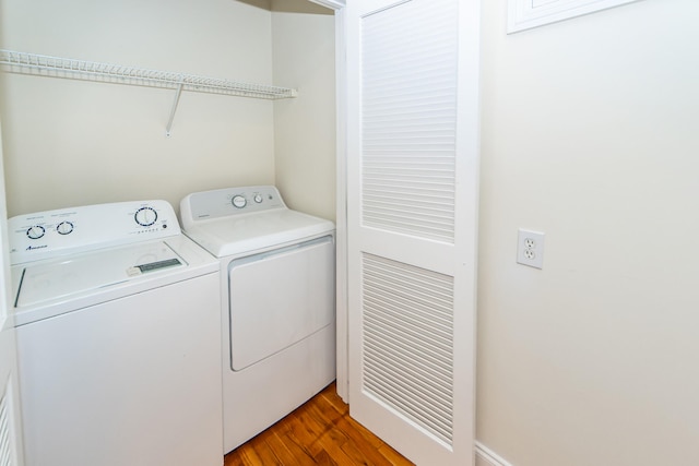 laundry room featuring separate washer and dryer and wood-type flooring