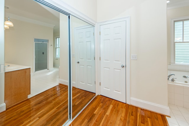 bathroom with ornamental molding, wood-type flooring, and shower with separate bathtub