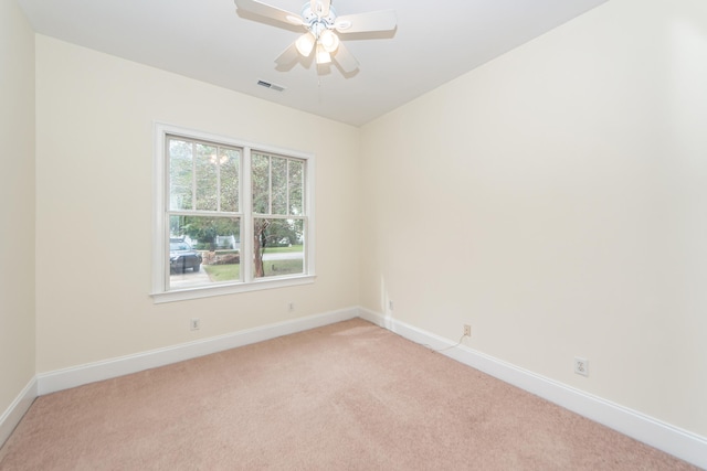 empty room featuring light colored carpet and ceiling fan