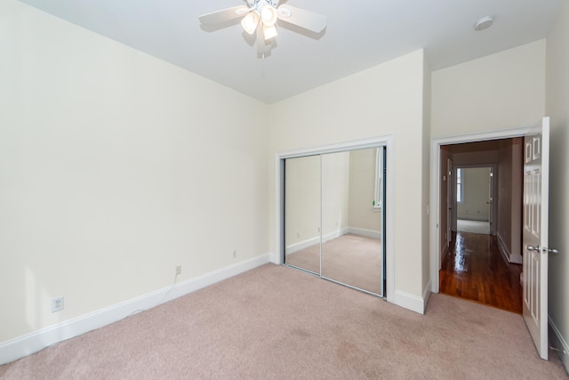 unfurnished bedroom with ceiling fan, a closet, and light carpet