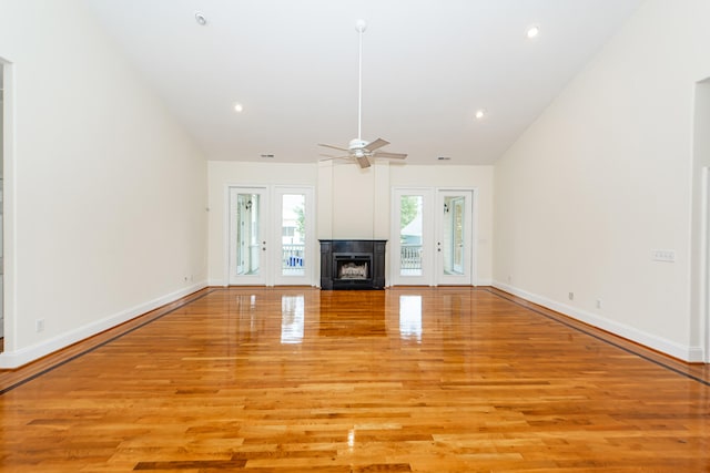 unfurnished living room featuring a multi sided fireplace, vaulted ceiling, light hardwood / wood-style flooring, and ceiling fan