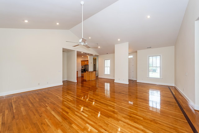 unfurnished living room featuring lofted ceiling, ceiling fan, and wood-type flooring