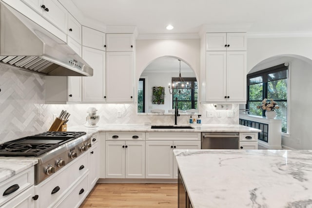 kitchen with white cabinetry, sink, decorative light fixtures, and light stone countertops