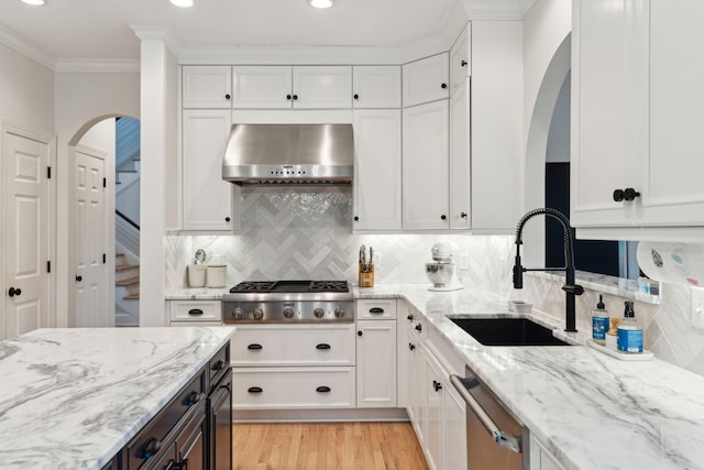 kitchen with sink, range hood, and white cabinets