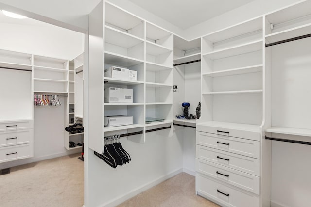 walk in closet featuring light carpet