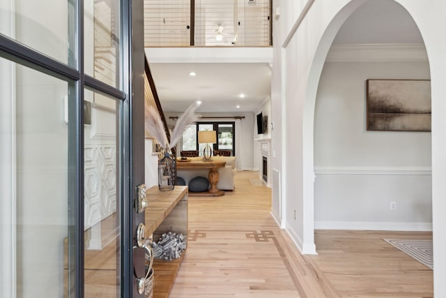 hallway featuring ornamental molding and light wood-type flooring