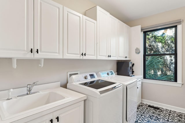 laundry room with cabinets, washer and dryer, sink, and light tile patterned floors