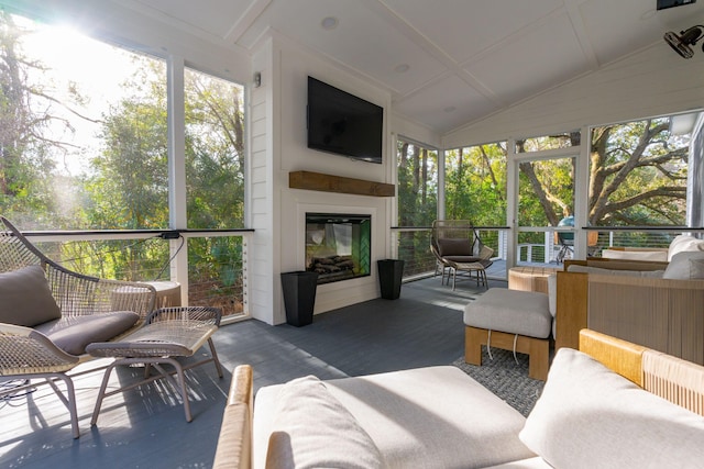 sunroom / solarium featuring vaulted ceiling and a large fireplace