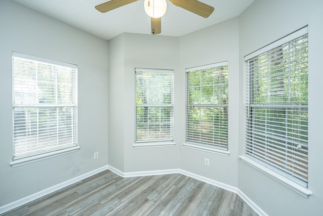 unfurnished room featuring ceiling fan, a healthy amount of sunlight, and light hardwood / wood-style floors