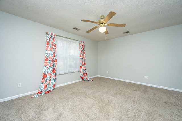 carpeted spare room with ceiling fan and a textured ceiling