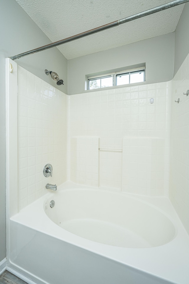 bathroom featuring a textured ceiling and shower / washtub combination