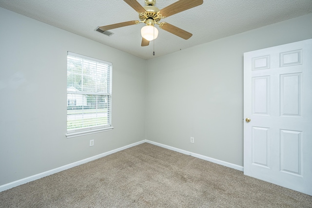 empty room featuring light carpet, ceiling fan, and a textured ceiling