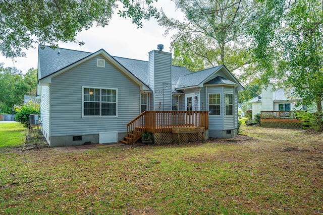 rear view of house featuring a yard and a deck